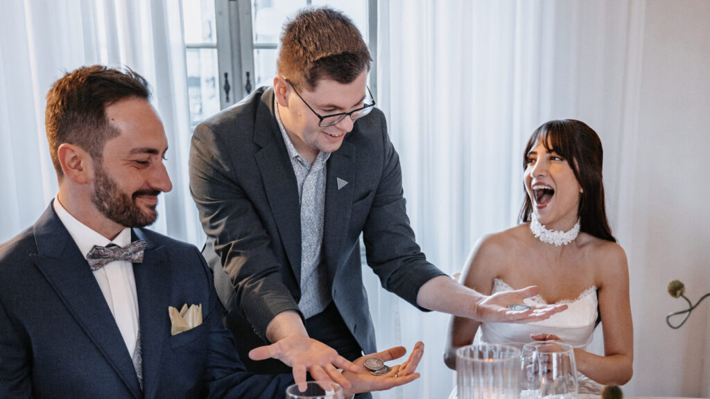 Zauberer zeigt Tricks am Tisch.