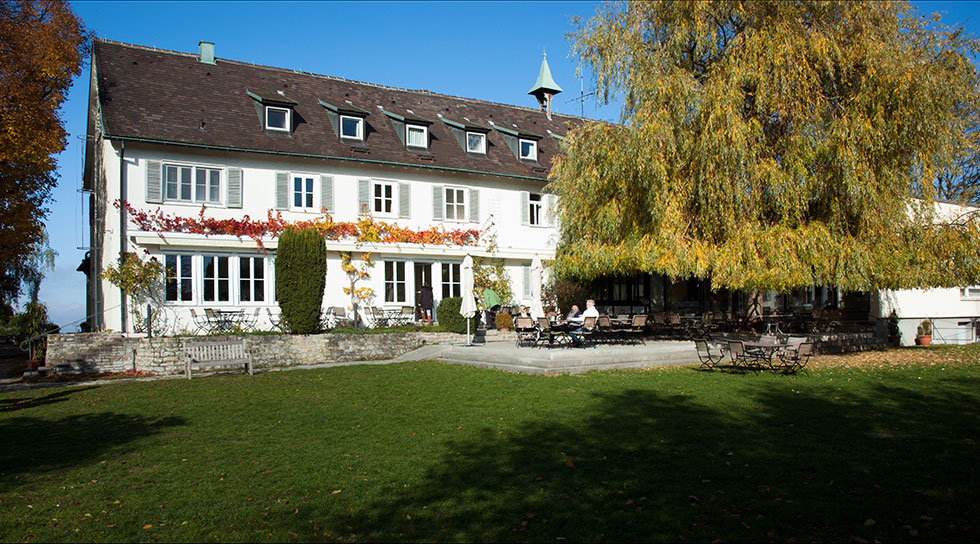 Landgut Burg in Weinstadt: Hauptgebäude mit Terrasse und Garten im Herbst