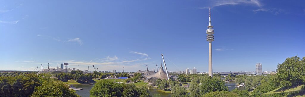 Panorama des Olympiaparks München mit Olympiaturm und Olympiasee