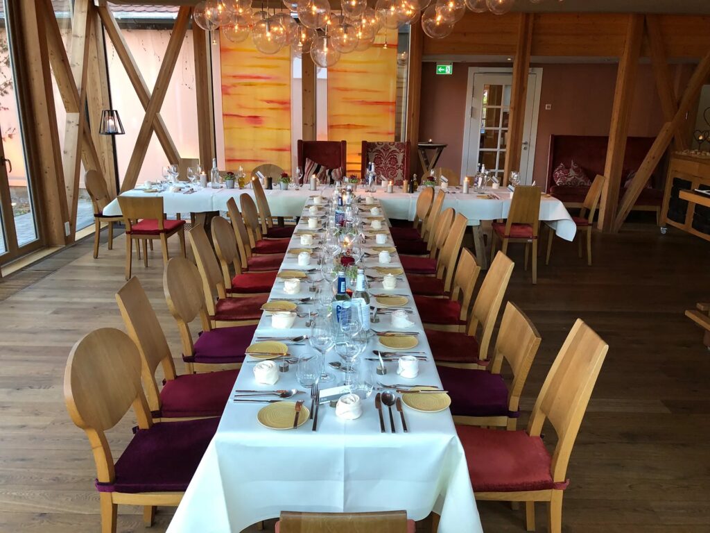 Lange festlich gedeckte Tafel im Schindlerhof Boxdorf mit Holzbalken und Lichterkugeln