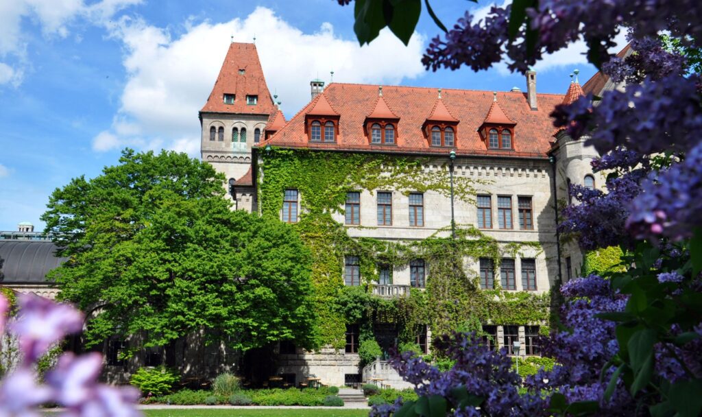 Schloss Faber-Castell in Stein bei Nürnberg mit efeubewachsener Fassade und blühendem Flieder