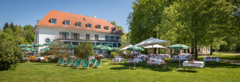 Biergarten und Haupthaus des Waldhaus zur alten Tram in Straßlach am Rand des Grünwalder Forsts, Location für Sommerfest und Firmenfeier