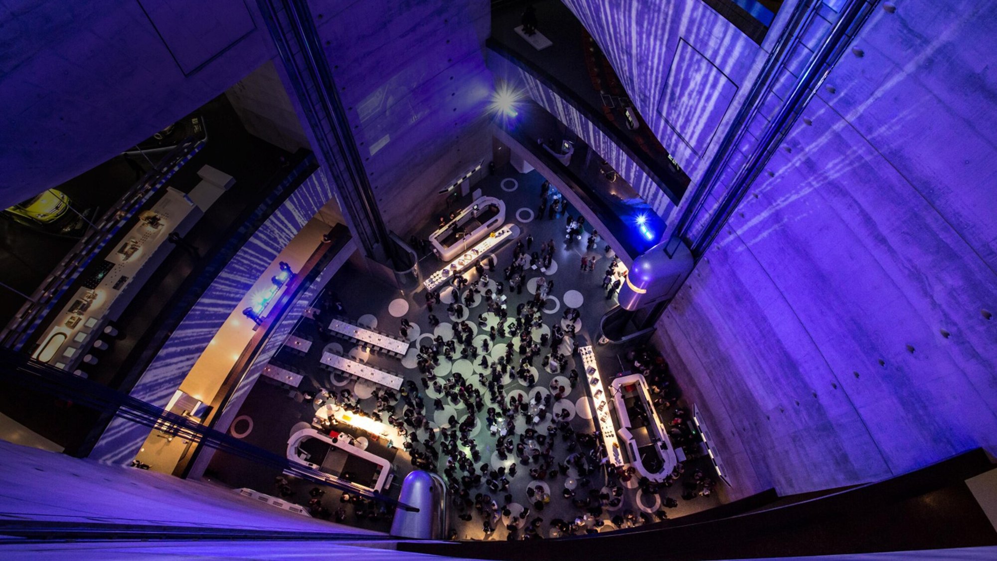 Abendempfang im Atrium des Mercedes-Benz Museums in Stuttgart, von oben fotografiert, mit violetter Beleuchtung